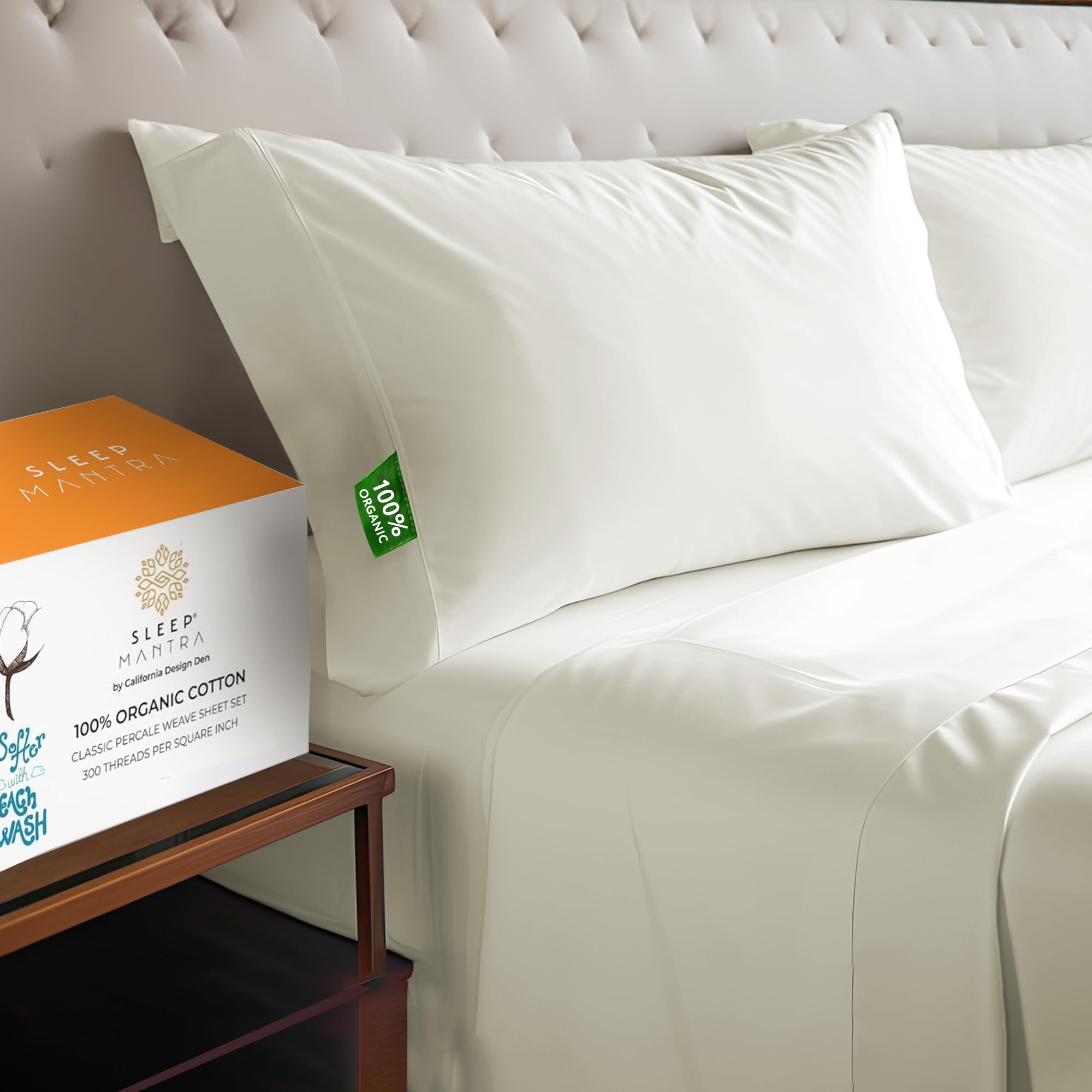 White organic cotton sheet set with pillows on a bed, product box visible