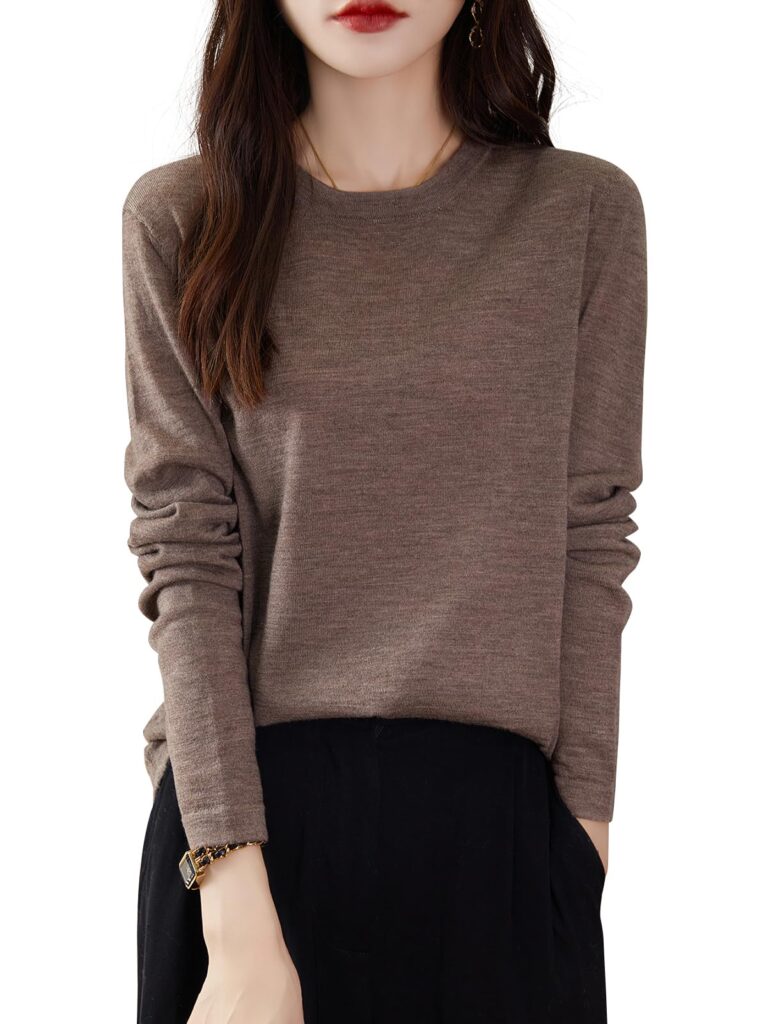 Woman wearing a brown sweater and black pants, hands in pockets