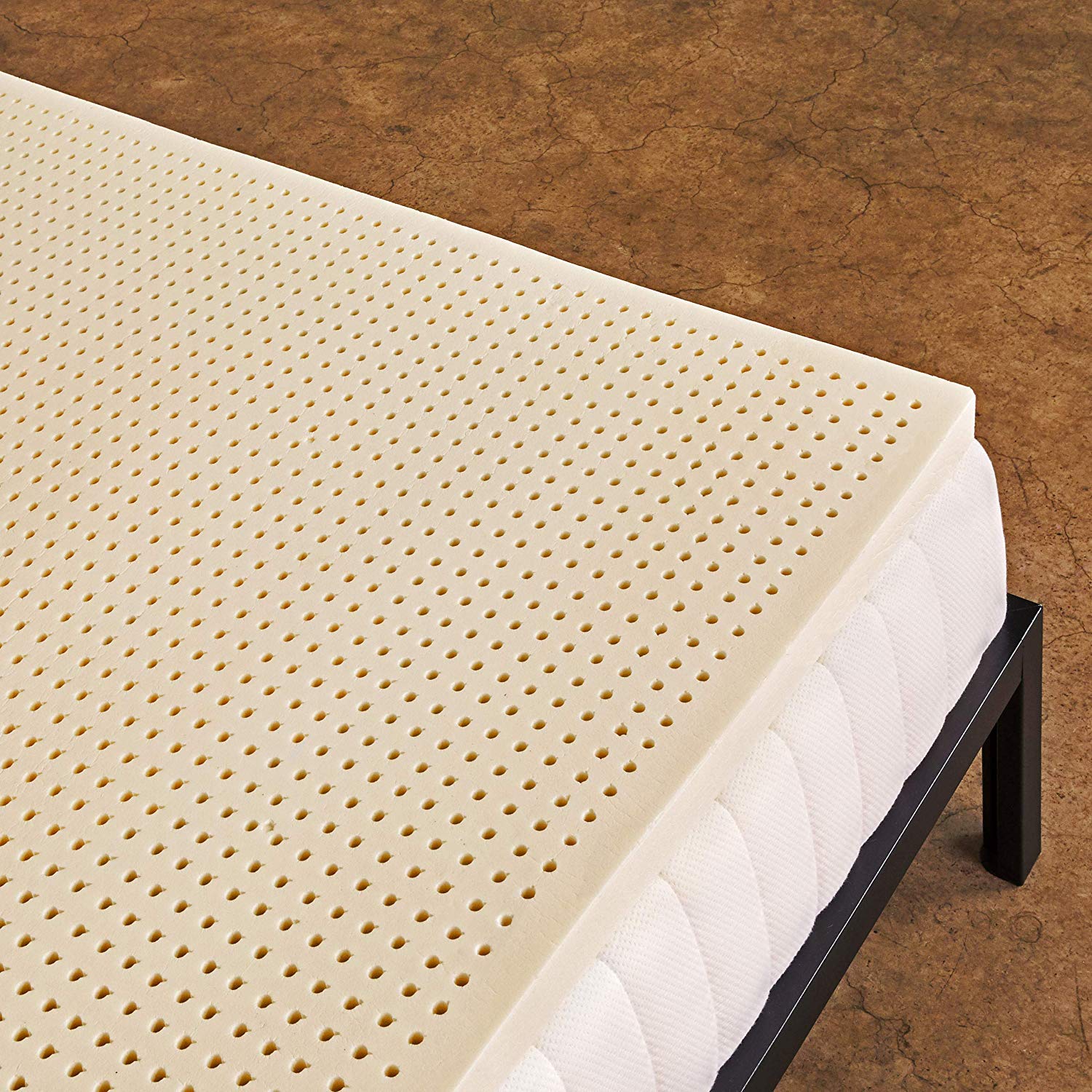 Mattress topper with small holes on top of a quilted mattress